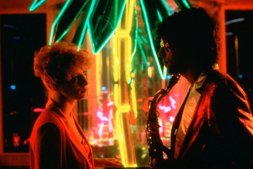 80s image of a man holding a sax looking at a woman